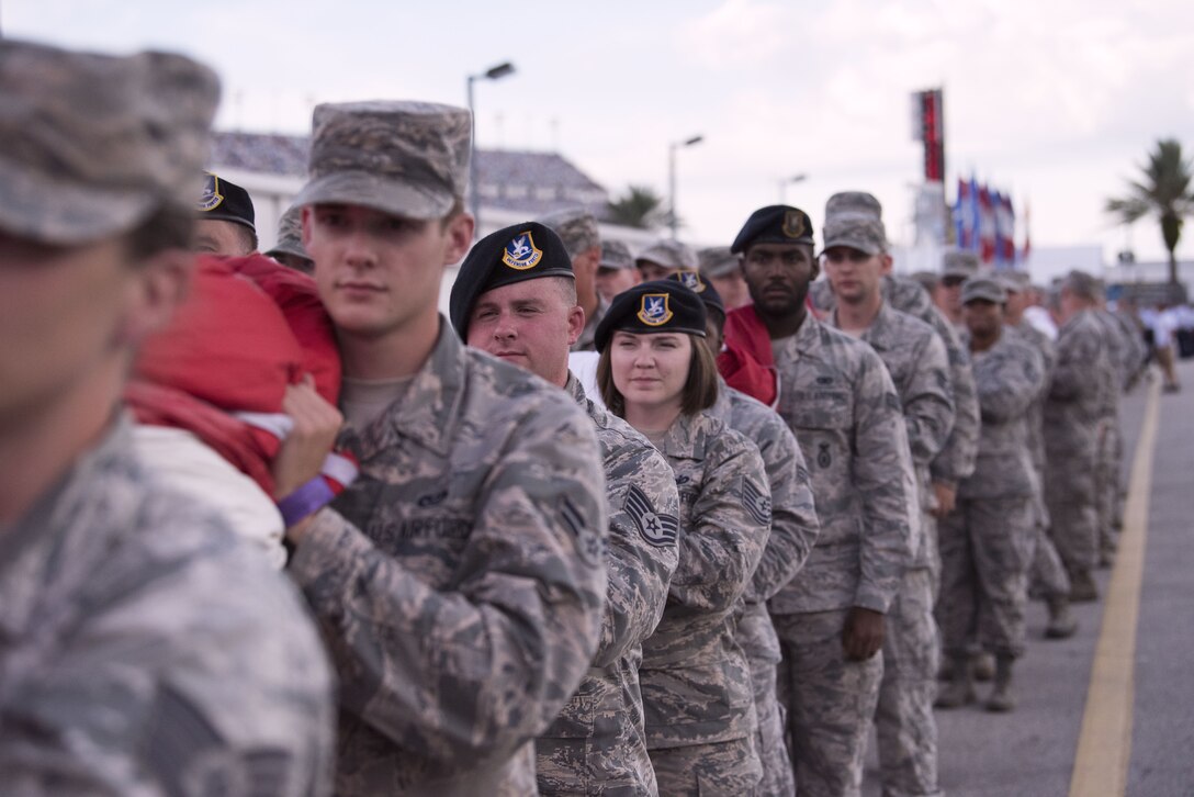 Approximately 150 service members gather to carry an American flag to the infield of Daytona International Speeway's racetrack for an unfurl during the National Anthem July 7, in Daytona Beach, Fla. The unfurl was part of the pre-race ceremonies for the Daytona Coke Zero Sugar 400. (U.S. Air Force photo by Airman 1st Class Zoe Thacker)