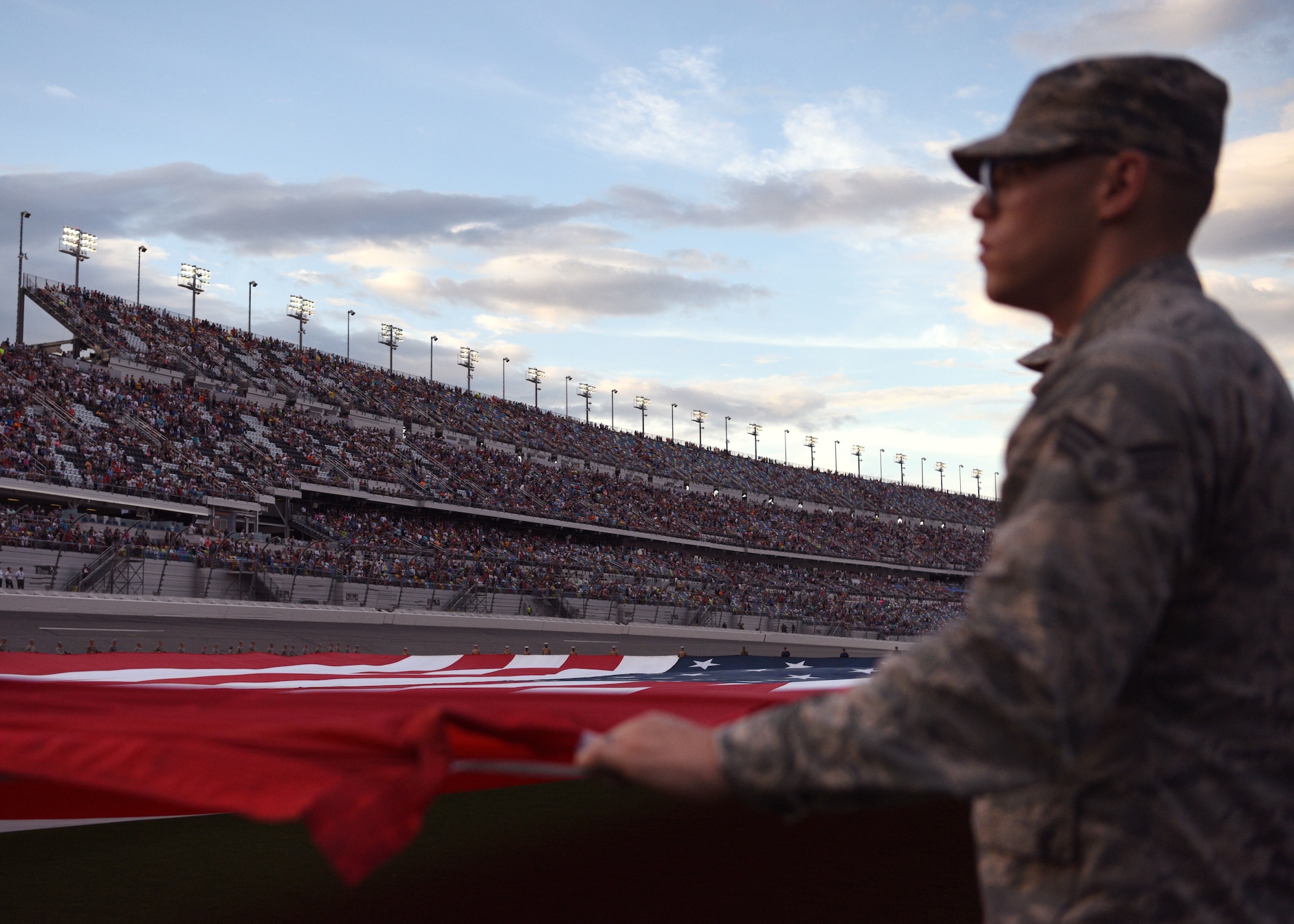 An airman from Patrick Air Force Base holds his military bearing during the National Anthem July 7, at the Daytona International Speedway in Daytona Beach, Fla. Airmen from Patrick AFB and Moody AFB were in attendance for the unfurling of the American flag – as well as representatives from all other military branches. (U.S Air Force photo by Airman 1st Class Zoe Thacker)