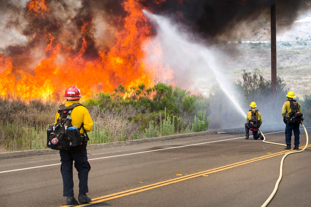 Firefighters with the Camp Pendleton Fire Department combat a wildfire.