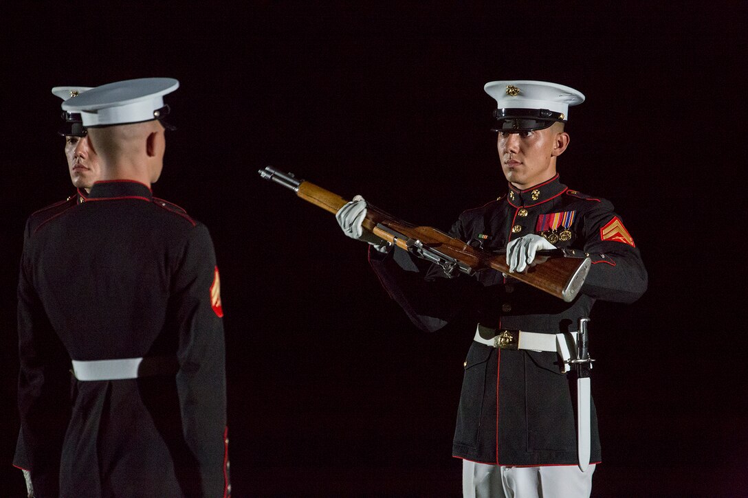 Corporal Darius Mick, rifle inspection team, U.S. Marine Corps Silent Drill Platoon, executes a rifle inspection during a Friday Evening Parade at Marine Barracks Washington D.C., July 6, 2018. The guests of honor for the parade were His Excellency Ambassador Virachai Plasai, ambassador of the Kingdom of Thailand to the U.S., and Minister Patrick A. Chuasoto, deputy chief of Mission, Embassy of the Republic of the Philippines to the U.S. The hosting official for the parade was Lt. Gen. Steven R. Rudder, deputy commandant of Aviation. (Official Marine Corps photo by Sgt. Robert Knapp/Released)