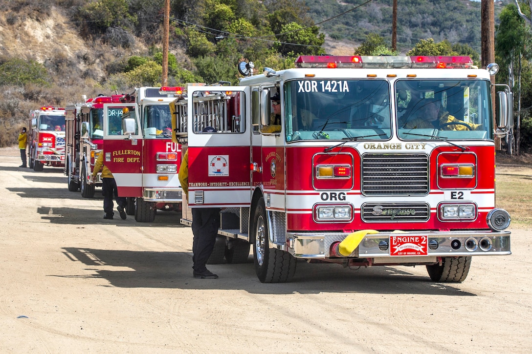 Firefighters with the Camp Pendleton Fire Department line up their fire trucks before combating a fire.