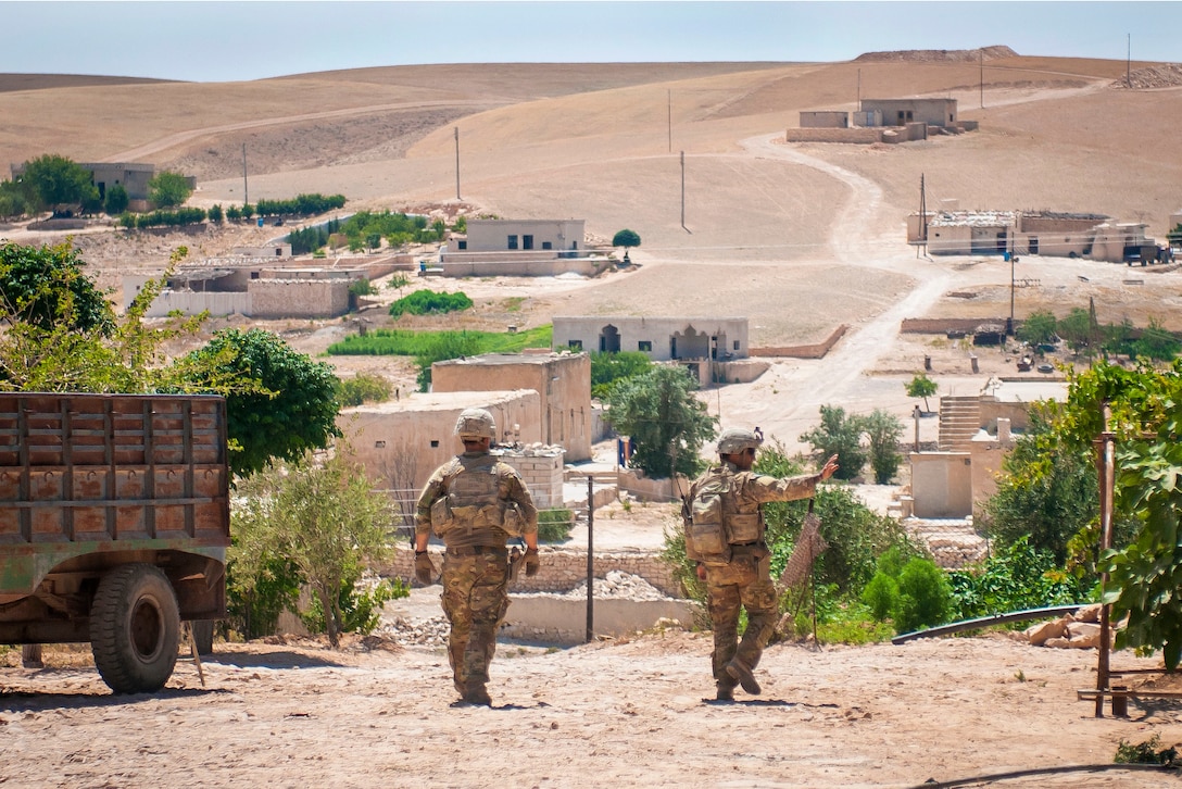 Soldiers wave to residents during a patrol.