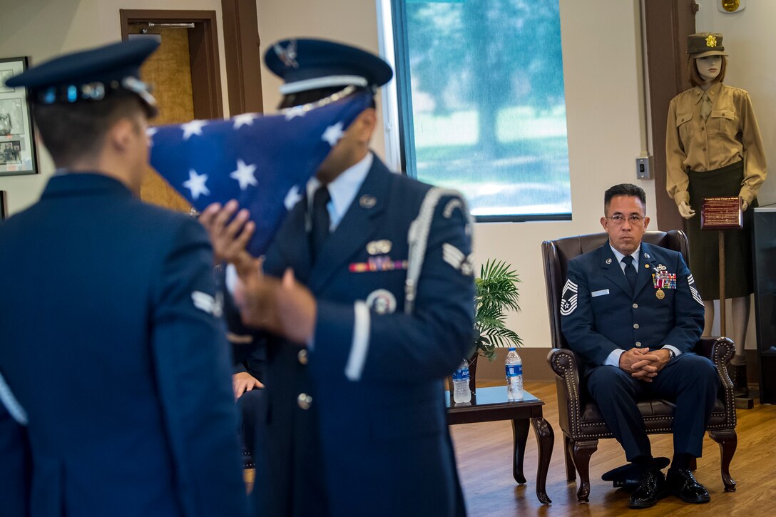Chief Master Sgt. Jay Banghart, 23d Maintenance Squadron operations chief, right, watches a flag folding ceremony during his retirement ceremony, July 6, 2018, at Moody Air Force Base, Ga. Banghart entered the Air Force in 1990 and served in numerous positions within the aircraft maintenance career field throughout his 28 year Air Force career. (U.S. Air Force photo by Airman 1st Class Eugene Oliver)