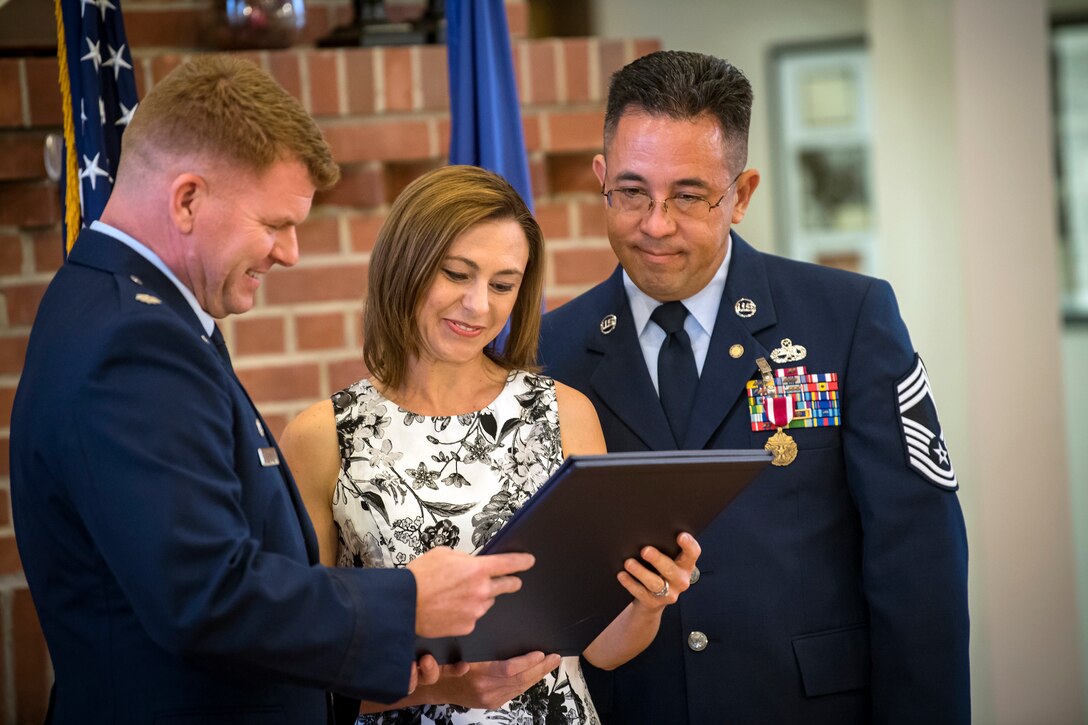 Lt. Col. Neal Van Houten, left, 23d Maintenance Squadron (MXS) commander, presents Jill Banghart with a certificate of appreciation during her husband Jay’s retirement ceremony, July 6, 2018, at Moody Air Force Base, Ga. Banghart entered the Air Force in 1990 and served in numerous positions within the aircraft maintenance career field throughout his 28 year Air Force career. (U.S. Air Force photo by Airman 1st Class Eugene Oliver)
