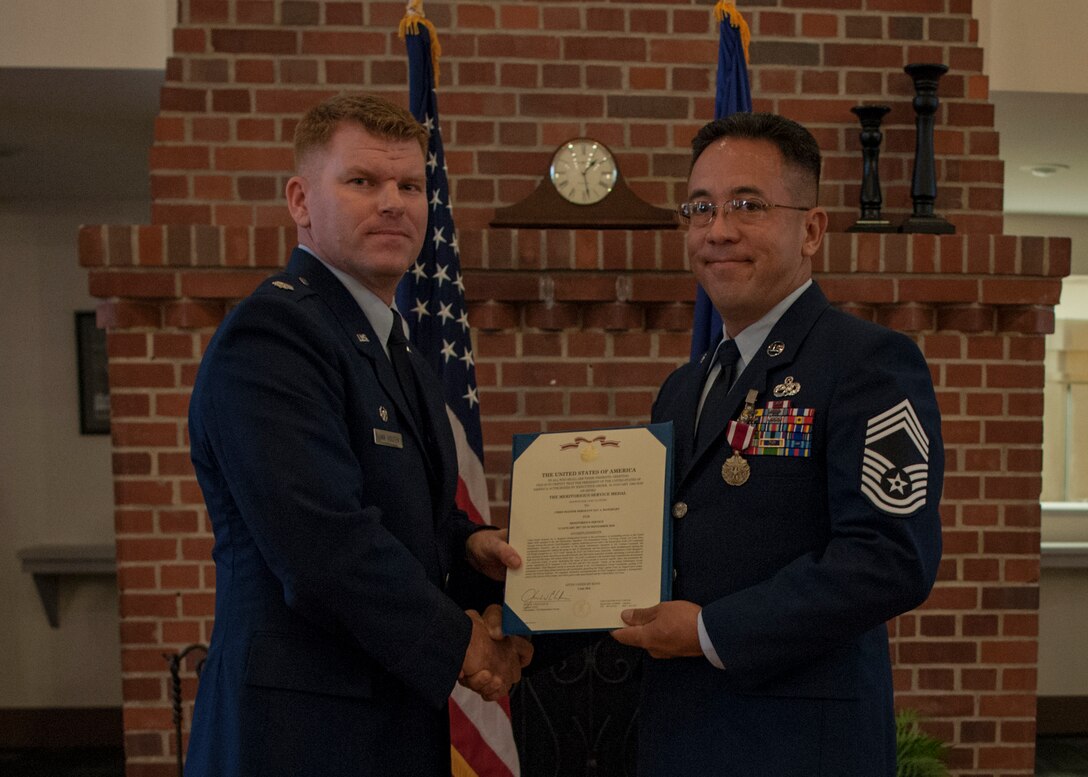 Lt. Col. Neal Van Houten, left, 23d Maintenance Squadron (MXS) commander, presents Chief Master Sgt. Jay Banghart, 23d MXS operations chief, with a Meritorious Service certificate during a retirement ceremony, July 6, 2018, at Moody Air Force Base, Ga. Banghart retired after serving 28 years in the Air Force in numerous positions within the aircraft maintenance career field. (U.S. Air Force photo by Airman Taryn Butler)