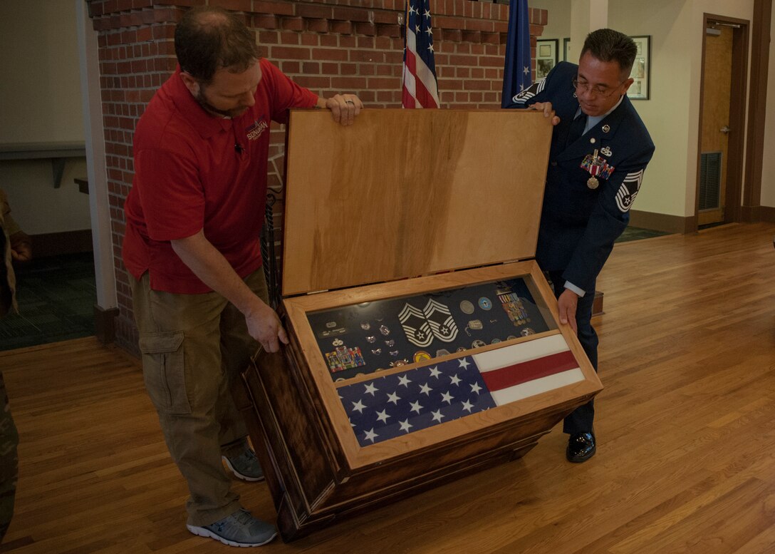 Chief Master Sgt. Jay Banghart, 23d Maintenance Squadron operations chief, receives a shadow box during a retirement ceremony, July 6, 2018, at Moody Air Force Base, Ga. Banghart retired after serving 28 years in the Air Force in numerous positions within the aircraft maintenance career field. (U.S. Air Force photo by Airman Taryn Butler)
