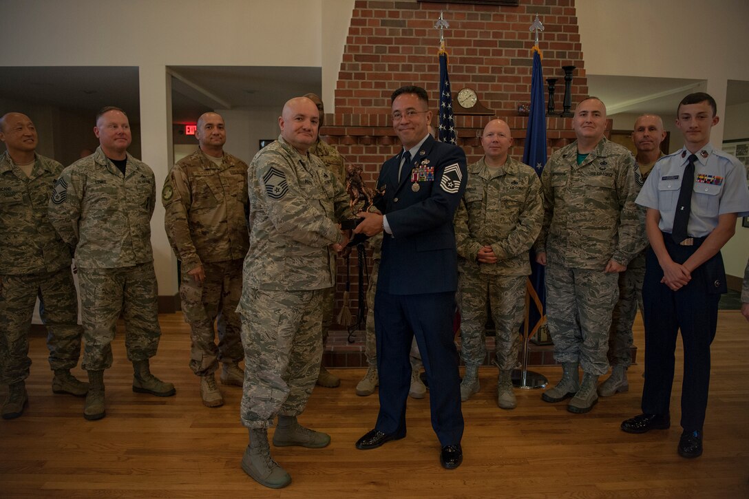 Chief Master Sgt. Brian Preyna, 23d Maintenance Group superintendent, presents an award to Chief Master Sgt. Jay Banghart, 23d Maintenance Squadron operations chief, during a retirement ceremony, July 6, 2018, at Moody Air Force Base, Ga. Banghart retired after serving 28 years in the Air Force in numerous positions within the aircraft maintenance career field. (U.S. Air Force photo by Airman Taryn Butler)
