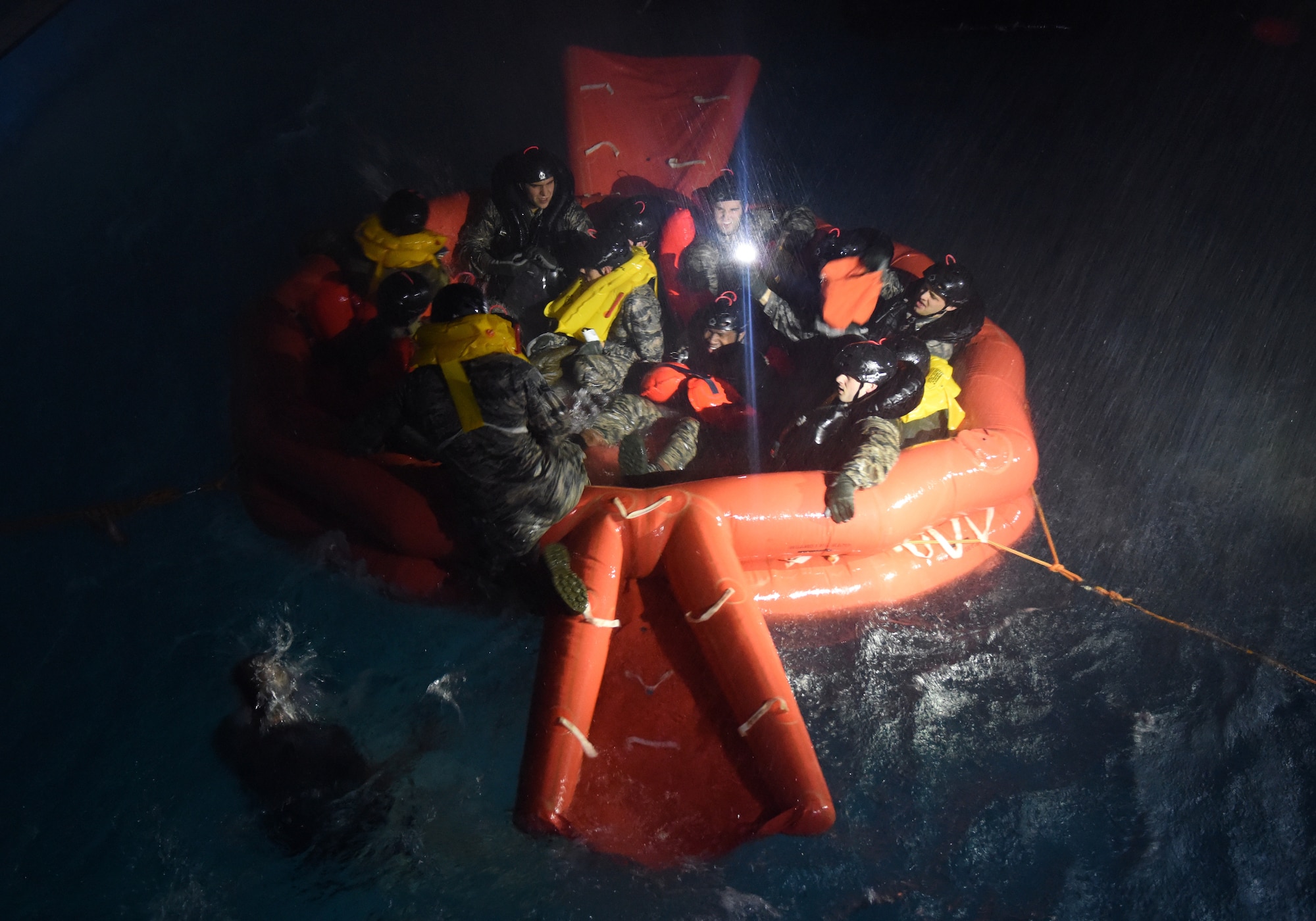 U.S. Air Force Airmen assigned to Royal Air Force Lakenheath survive the simulated heavy wind, rain and waves on a 20-man life raft during a Water Survival Course at East Coast College, Lowestoft, England, on May 4, 2018.