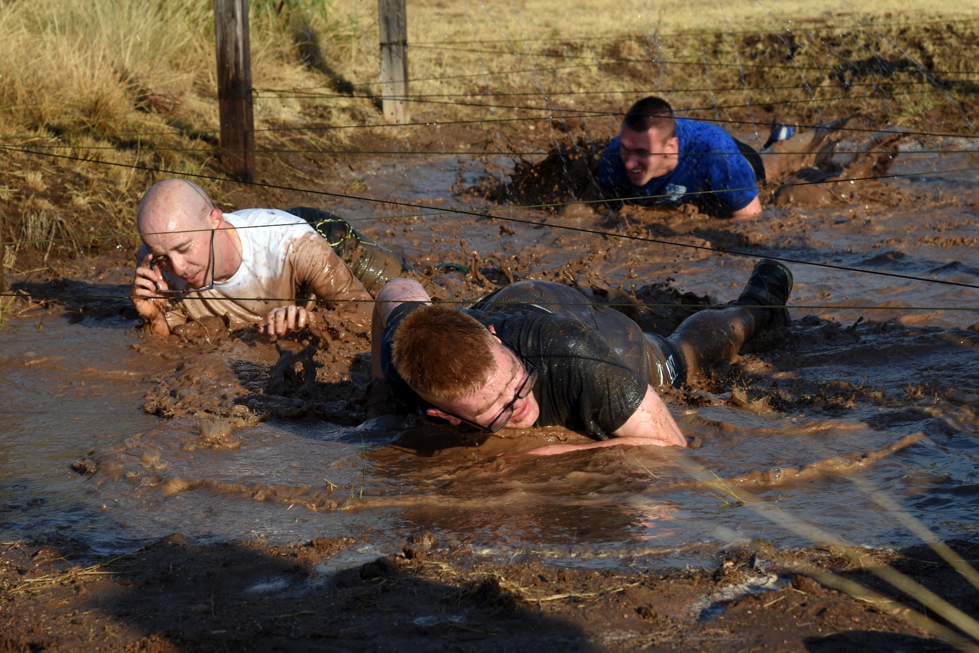 U.S. Army Pvt. Conner McCage, 344th Military Intelligence Battalion trainee, leads some other soldiers through a low crawl during the 344th MI BN mud run at the Camp Sentinel training area on Goodfellow Air Force Base, Texas, July 7, 2018. This was the 344th MI BN’s first ever mud run. (U.S. Air Force photo by Staff Sgt. Joshua Edwards/Released)
