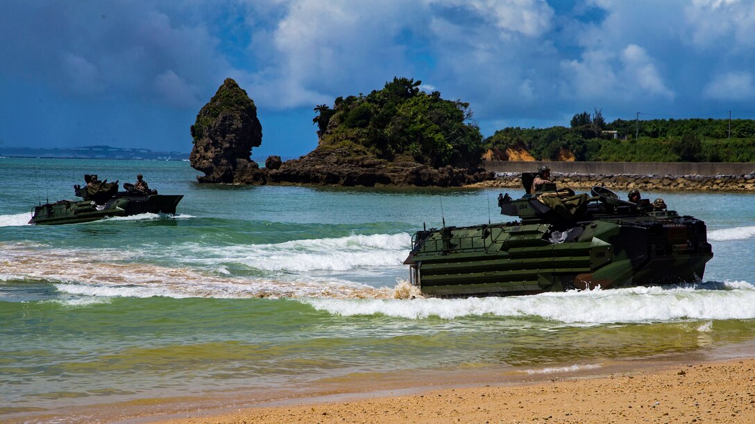 Marines in assault amphibious vehicles come ashore.