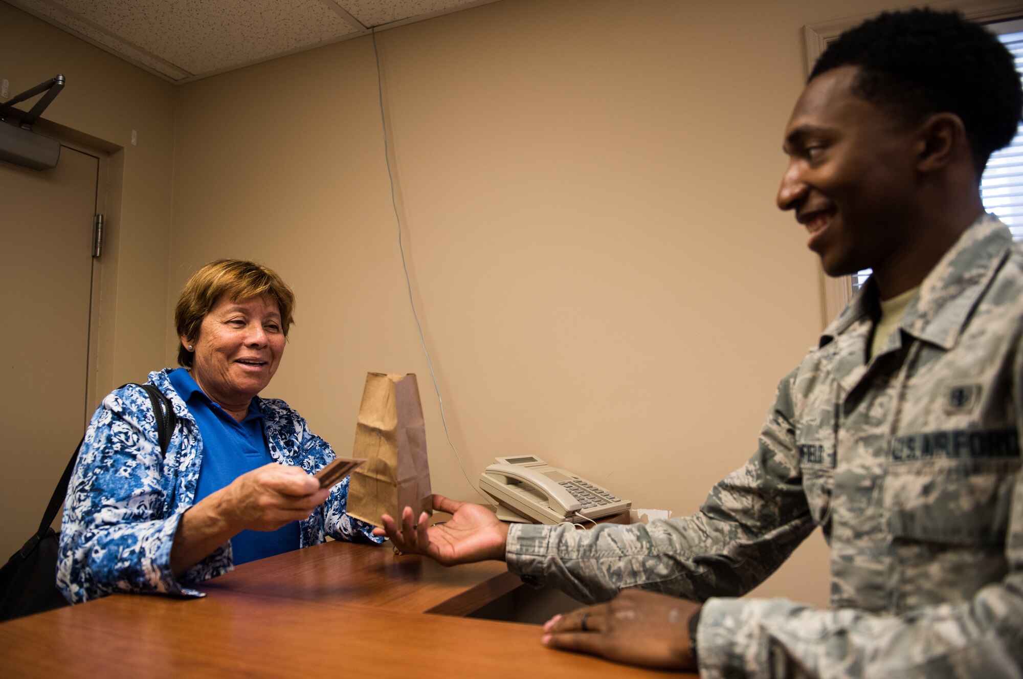 Senior Airman Cole Broomfield, 56th Medical Squadron pharmacy technician, provides a patient with their prescription medicine July 2, 2018 at the Luke Air Force Base Pharmacy Annex in Scottsdale, Ariz.  On average, the Luke AFB Pharmacy Annex, located in the east valley of Phoenix, serves prescription medicine to approximately 150 to 200 patients per week. (U.S. Air Force photo by Airman 1st Class Alexander Cook)