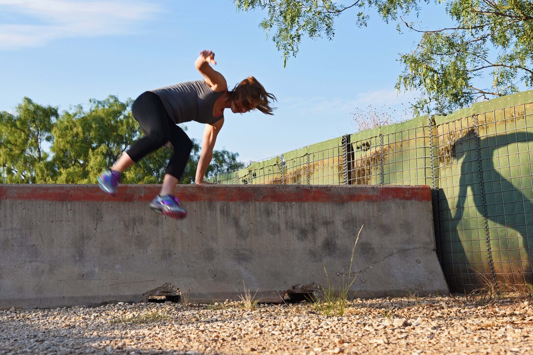 Army Pfc. Breanna Dagen jumps over a barrier.