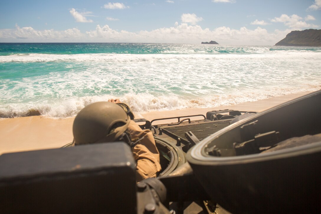 U.S. Marine Corps Lance Cpl. Alex Rojo, a crew chief with Combat Assault Company, 3rd Marine Regiment, awaits orders to enter the water during splash training at Pyramid Rock Beach as part of the Rim of the Pacific (RIMPAC) exercise on Marine Corps Base Hawaii July 8, 2018. RIMPAC provides high-value training for task-organized, highly capable Marine-Air Ground Task Force and enhances the critical crisis response capability of U.S. Marines in the Pacific. Twenty-five nations, 46 ships, five submarines, about 200 aircraft, and 25,000 personnel are participating in RIMPAC from June 27 to Aug. 2 in and around the Hawaiian Islands and Southern California.