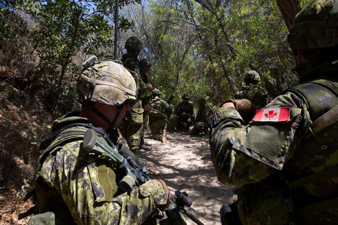Canadian soldiers with the Royal 22e Régiment plan a squad-level attack at a live-fire range during Rim of the Pacific (RIMPAC) exercise at Marine Corps Base Camp Pendleton, California, July 6, 2018. The training provided a dynamic environment, challenging leaders at the fire team and squad level by requiring the soldiers to react to pop-up targets in a tactical setting. RIMPAC provides high-value training for task-organized, highly-capable Marine Air-Ground Task Force and enhances the critical crisis response capability of U.S. Marines in the Pacific. Twenty-five nations, 46 ships, five submarines, about 200 aircraft and 25,000 personnel are participating in RIMPAC from June 27 to Aug. 2 in and around the Hawaiian Islands and Southern California.
