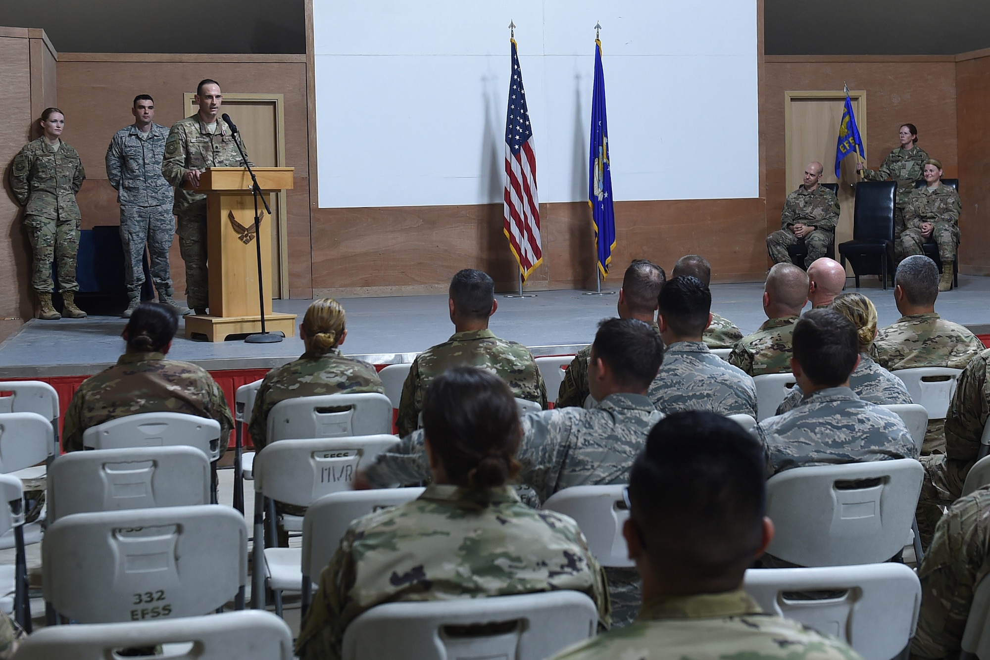 An Airman stands behind a podium to speak to an audience