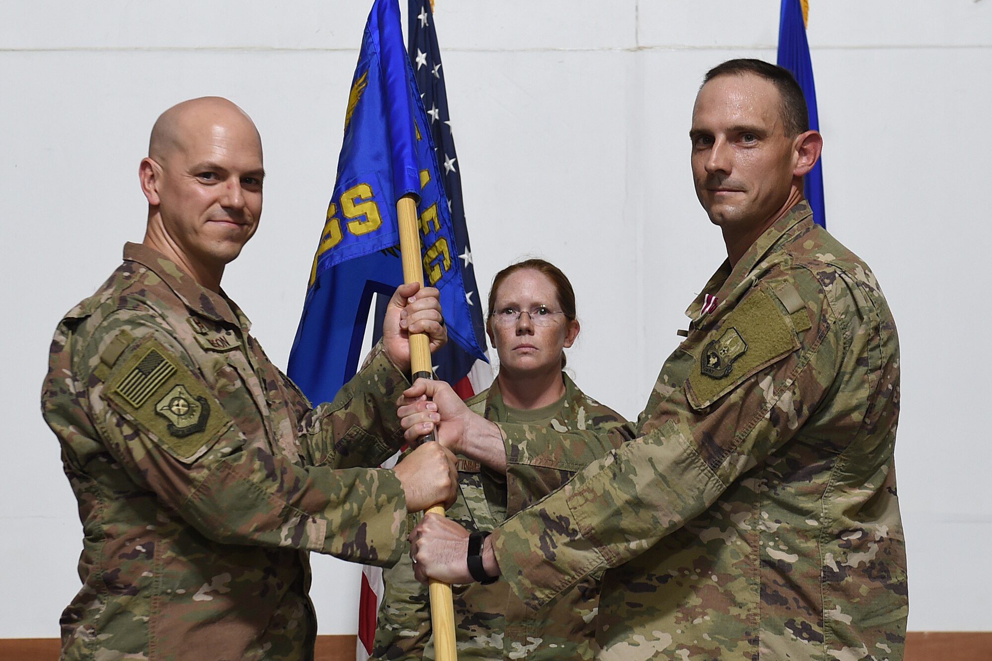 Two Airmen hold the squadron flag
