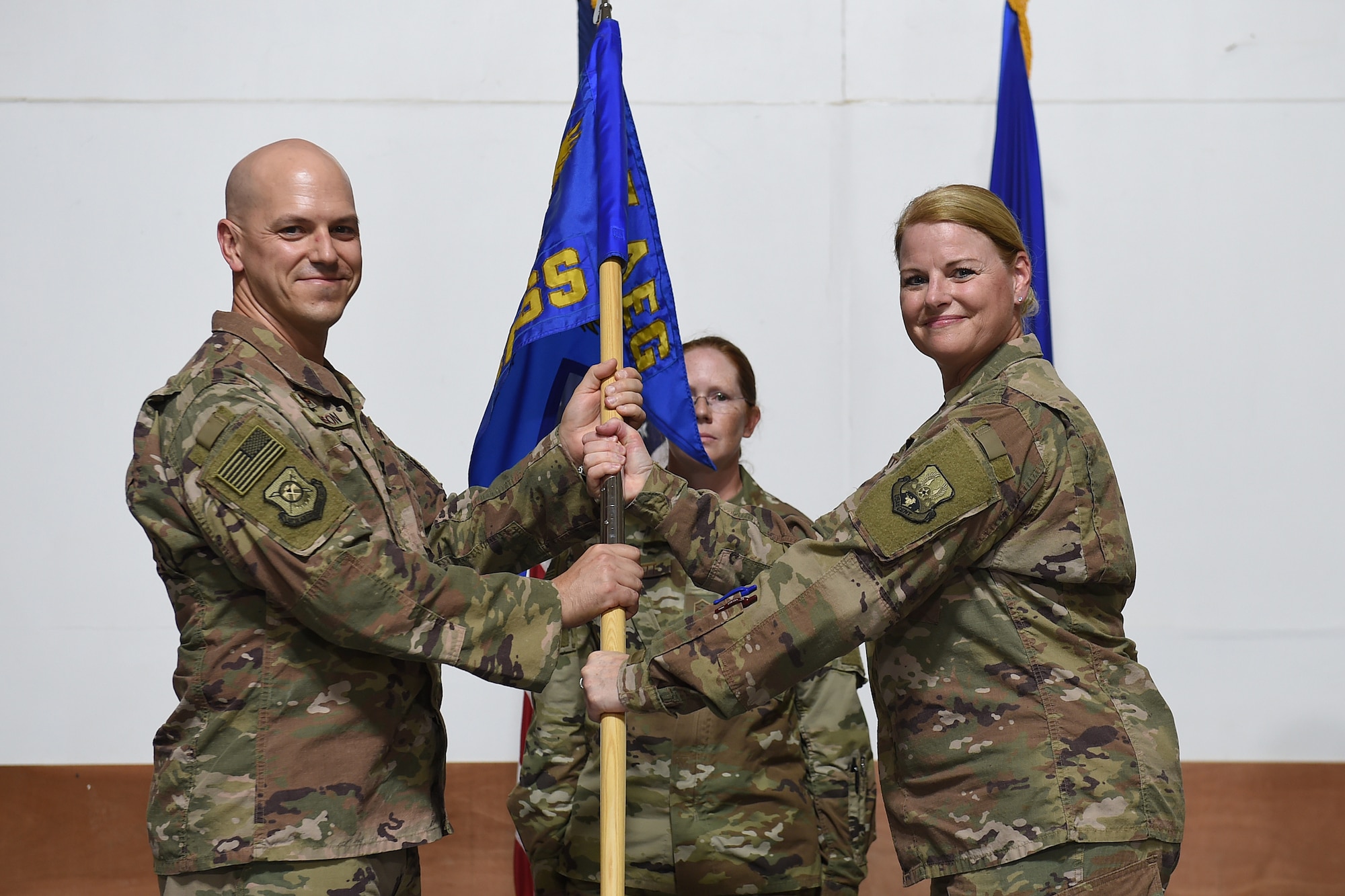 Two Airmen hold a squadron flag