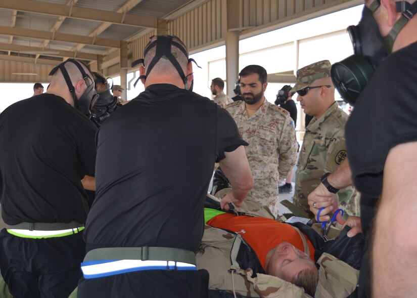 First Lt. Nawaf Tawfeeq Al-Awadi (center, facing camera), a chemical officer with the Kuwait Minister of Defense Weapons of Mass Destruction Defense Directorate, and Sgt. 1st Class Joel Santana, an instructor with U.S. Army Medical Research Institute of Chemical Defense (USAMRICD) observe the treatment of a simulated casualty June 27, 2018 during a weapons of mass destruction training event. The practical exercise followed two days of classroom instruction.