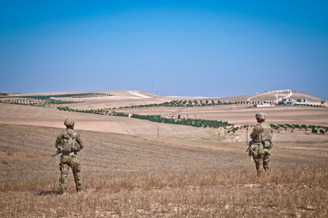 Soldiers maneuver along a hillside while providing security during a coordinated, independent patrol.