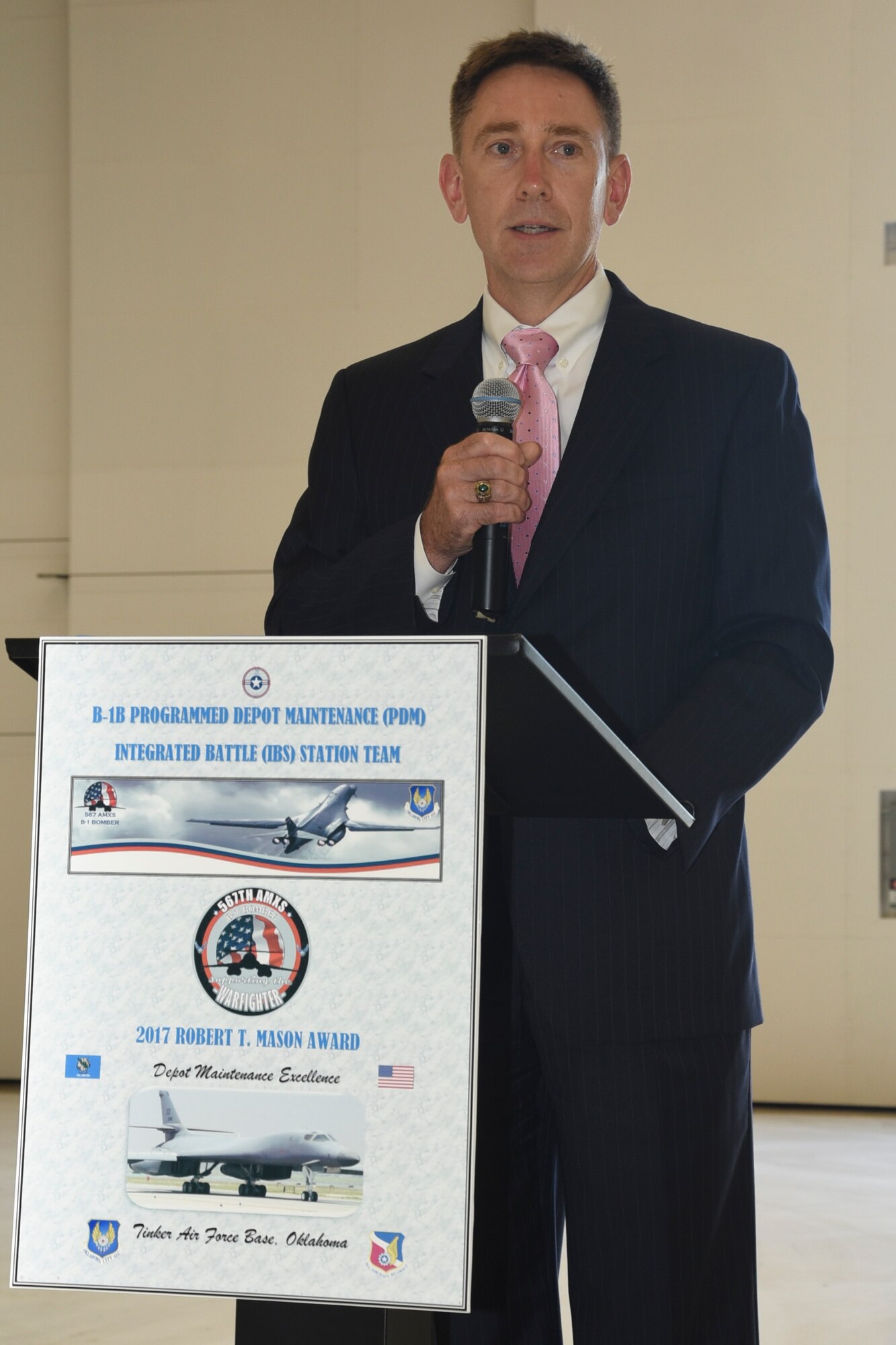 Ken Watson, Assistant Secretary of Defense for Maintenance, Policy and Programs, speaks from the podium inside hangar 2122 as he presents the Robert T. Mason award to the 567th Aircraft Maintenance Squadron on June 27, 2018, Tinker Air Force Base, Oklahoma. The 567th AMXS received the award for their work on the B-1B Programmed Depot Maintenance Integrated Battle Station upgrades.