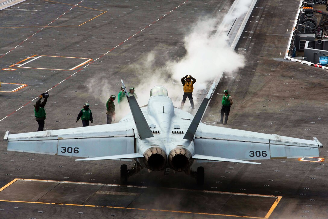 A hornet prepares to launch off the flight deck of the Nimitz-class aircraft carrier USS John C. Stennis.