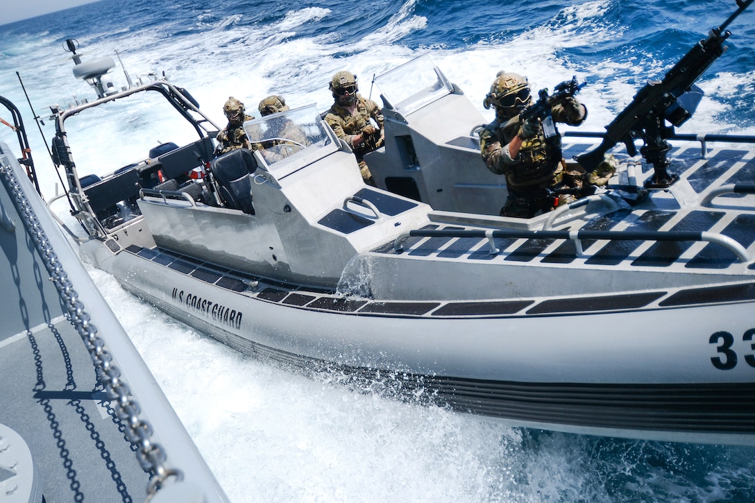 U.S. Coast Guard members in high speed boat approaches a vessel.