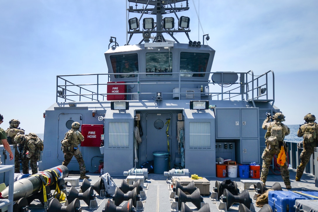 U.S. Coast Guard members and Canadian sailors search a vessel as they conduct maritime interdiction operations training.