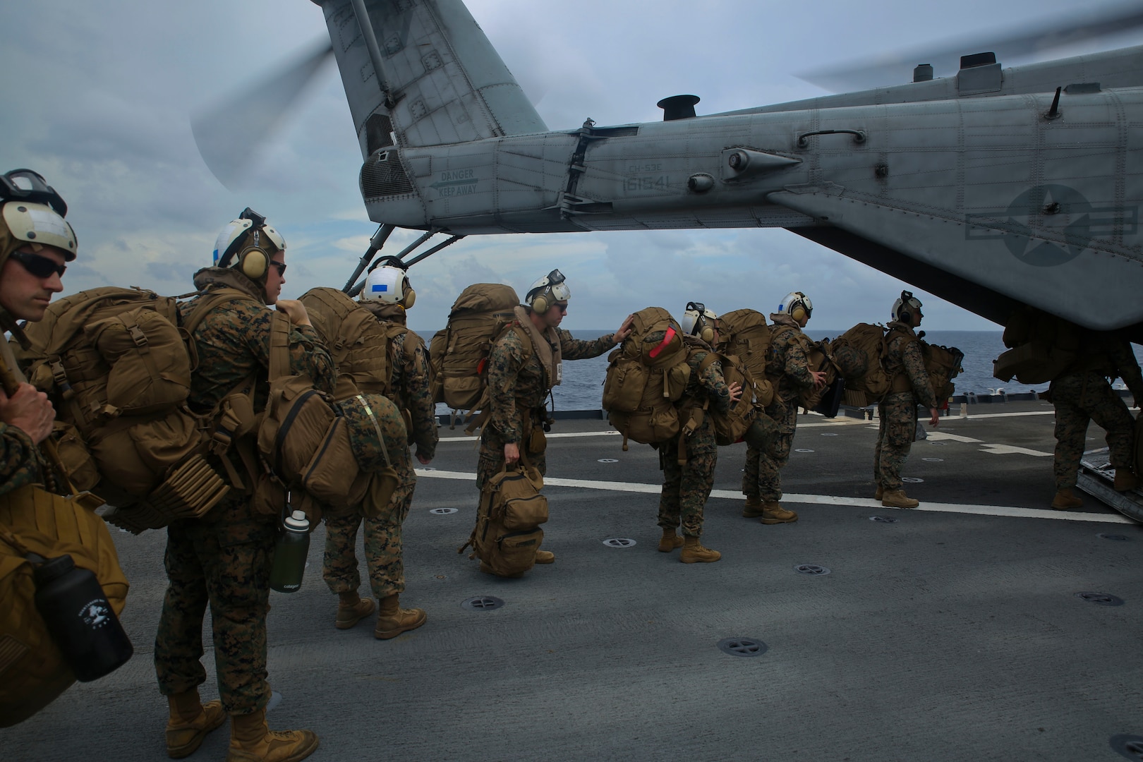 U.S. Marines board a helicopter on USS Gunston Hall.
