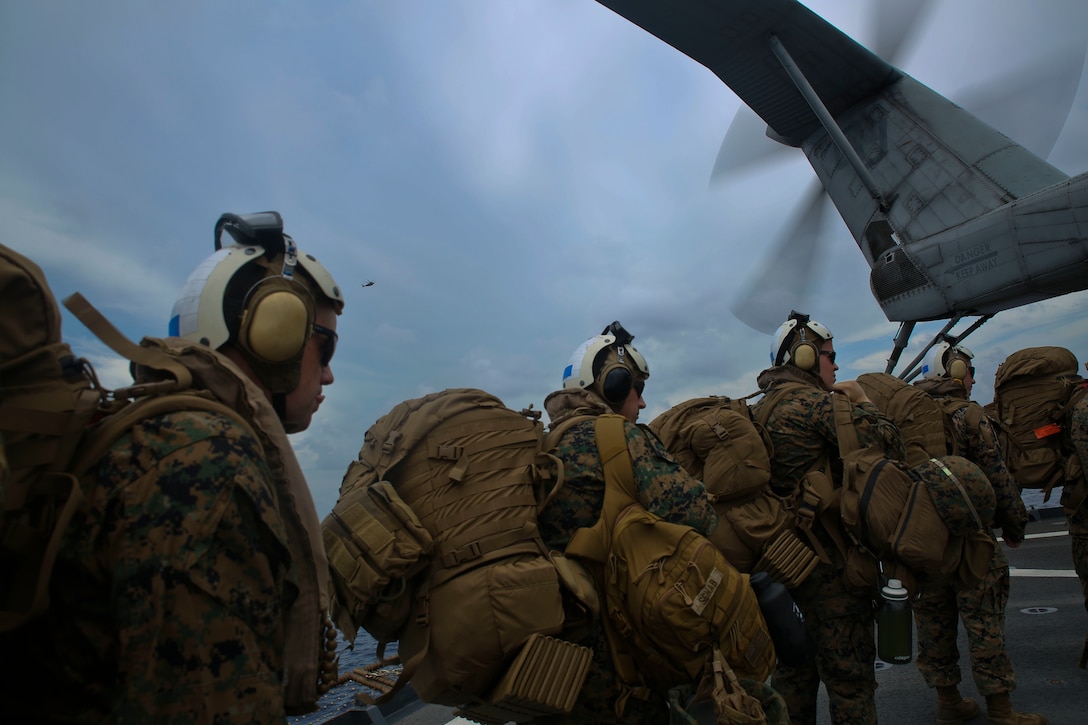 U.S. Marines board a helicopter on USS Gunston Hall.