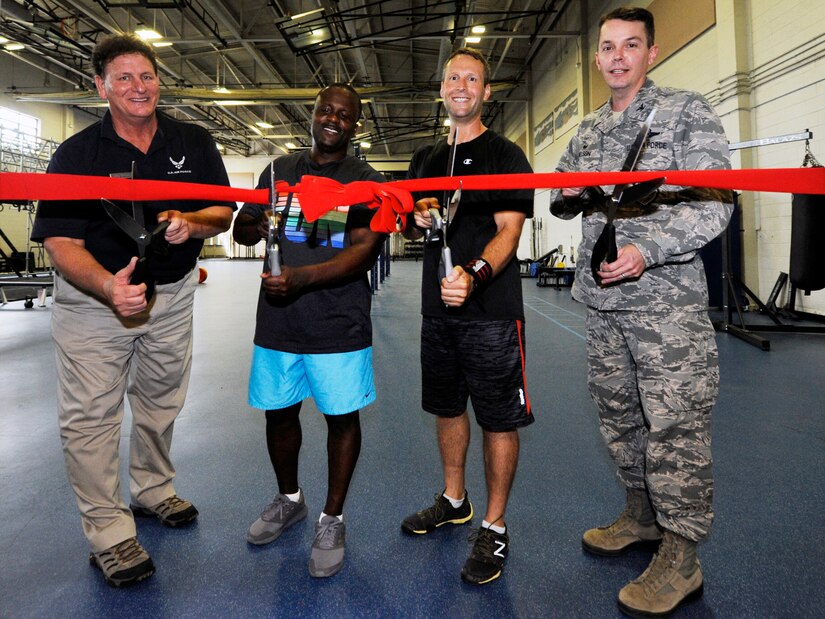Col. Jeff Nelson, right, 628th Air Base Wing commander, and Steve Parrish, left, 628th Force Support Squadron Fitness and Sports Center director, celebrate improvements made to the Air Base fitness center with Staff Sgt. Malik Khaalis, center left, 315th Maintenance Squadron, and Master Sgt. Seth Gressley, 437th MXS, during a ribbon cutting ceremony here, July 9, 2018. The ceremony highlighted the opening of the center’s functional fitness room and upgraded men’s showers. The 628th FSS invested more than $700,000 in new fitness equipment and renovated the open bay shower area into nine individual custom showers.