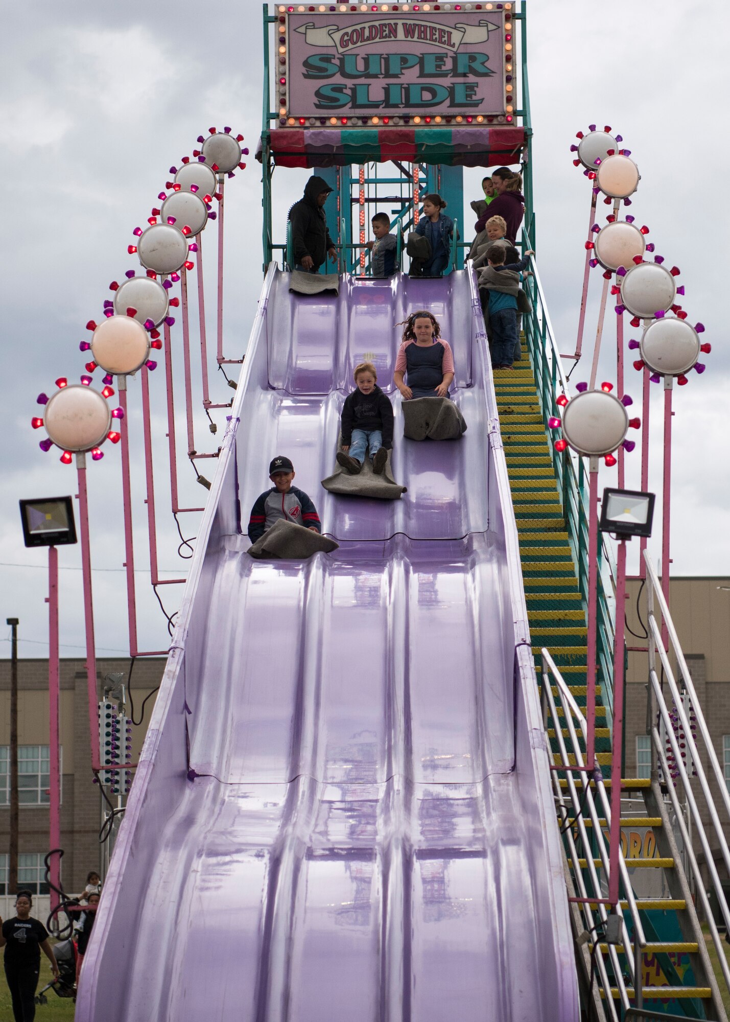 Children ride the “Golden Wheel Super Slide” during the 3rd annual Summer Fest hosted by the 673d Force Support Squadron at Joint Base Elmendorf-Richardson, Alaska, July 8, 2018. The event was open to anyone with base access and offered free activities such as carnival rides, a petting zoo, face painting, a bungee trampoline, and carnival games.
