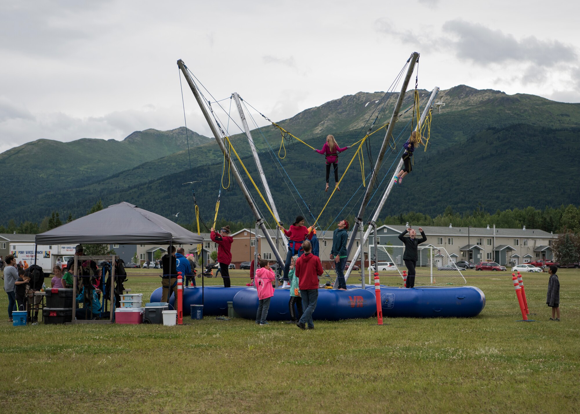 Children bounce on the bungee trampolines during the 3rd annual Summer Fest hosted by the 673d Force Support Squadron at Joint Base Elmendorf-Richardson, Alaska, July 8, 2018. The event was open to anyone with base access and offered free activities such as carnival rides, a petting zoo, face painting, a bungee trampoline, and carnival games.