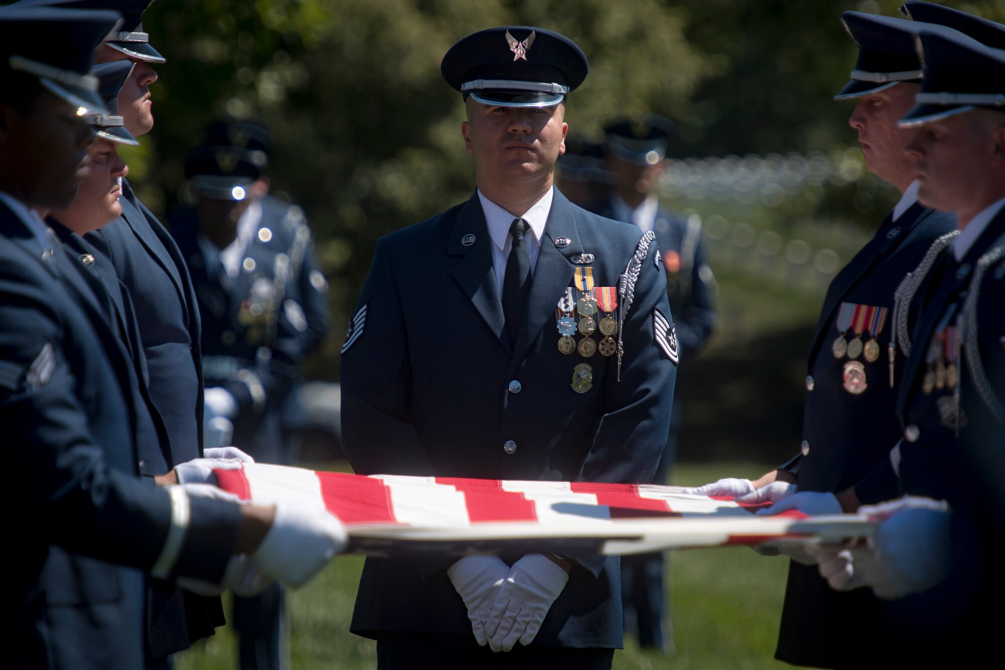 Members of the U.S. Air Force Honor Guard prepare to fold the flag above Capt. Mark Weber’s casket during his funeral service, July 9, 2018, at Arlington National Cemetery, Va. Weber, a 38th Rescue Squadron combat rescue officer and Texas native, was killed in an HH-60G Pave Hawk crash in Anbar Province, Iraq, March 15. Friends, family, and Guardian Angel Airmen traveled from across the U.S. to attend the ceremony and pay their final respects. (U.S. Air Force photo by Staff Sgt. Ryan Callaghan)