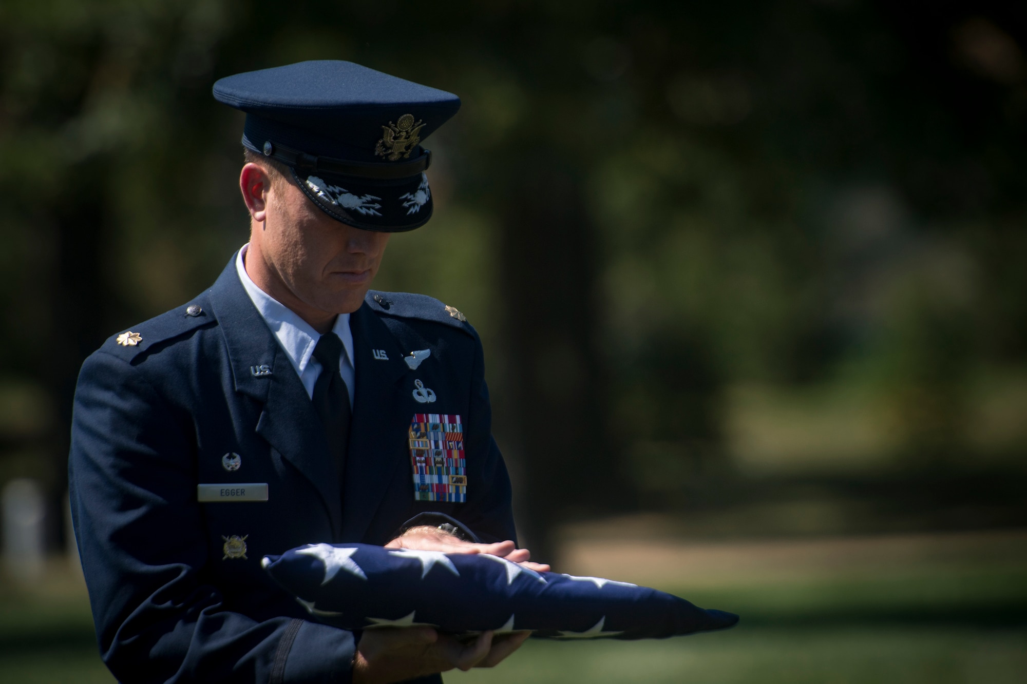 Maj. Jason Egger, 38th Rescue Squadron commander, carries a folded flag during a funeral service for Capt. Mark Weber, July 9, 2018, at Arlington National Cemetery, Va. Weber, a 38th RQS combat rescue officer and Texas native, was killed in an HH-60G Pave Hawk crash in Anbar Province, Iraq, March 15. Friends, family, and Guardian Angel Airmen traveled from across the U.S. to attend the ceremony and pay their final respects. (U.S. Air Force photo by Staff Sgt. Ryan Callaghan)
