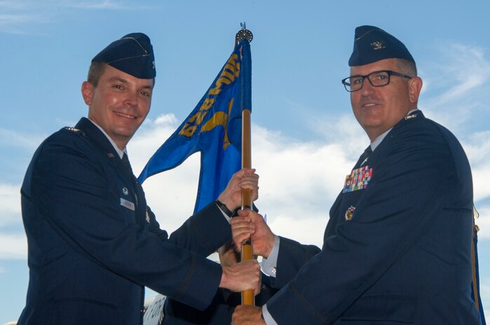 Col. Brian Musselman, right, accepts the 628th Medical Group guidon from Col. Jeffrey Nelson, 628th Air Base Wing commander, during a change of command ceremony in Nose Dock 2 July, 10, 2018. The ceremony also honored Lt. Col. Michael Lewis for his accomplishments as commander. The 16th AS commander is responsible for more than 150 combat crewmembers who execute C-17 Globemaster III airlift missions worldwide for DOD and National Command Authority directives. The change of command ceremony provides an opportunity for subordinates to witness the formal transfer of total responsibility, authority and accountability from one officer to the next.
