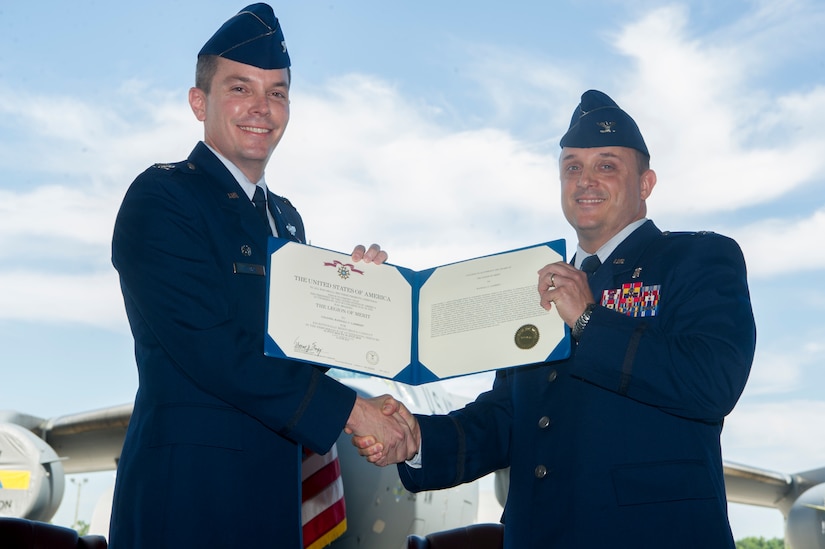 Col. Jeffrey Nelson, left, 628th Air Base Wing commander, presents Col. Craig Lambert with the Legion of Merit for his outstanding contributions as the 628th Medical Group commander during a change of command ceremony July, 10, 2018 in Nose Dock 2. The change of command ceremony provides an opportunity for subordinates to witness the formal transfer of total responsibility, authority and accountability from one officer to the next.