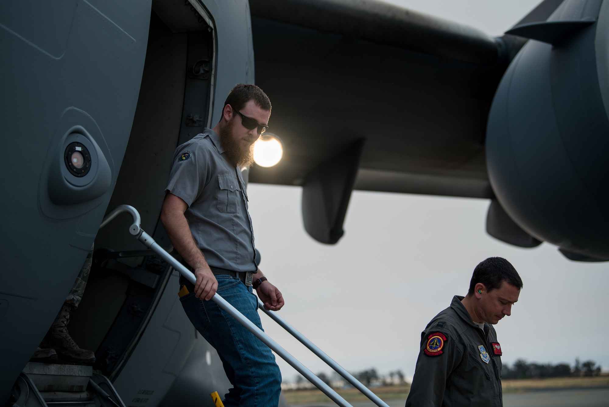 Matt Stevens, left, a U.S. Department of Agriculture airport biologist, and U.S. Air Force Capt. Sean Harte, 60th Air Mobility Wing Safety Office flight commander, go over C-17 Globemaster III pre-flight procedures before a safety familiarization flight at Travis Air Force Base, Calif., July 2, 2018. The flight allowed Stevens, who helps manage the Bird/Wildlife Aircraft Strike Program at Travis to get a firsthand view of what pilots see during training flights near the base. (U.S. Air Force photo by Master Sgt. Joey Swafford)