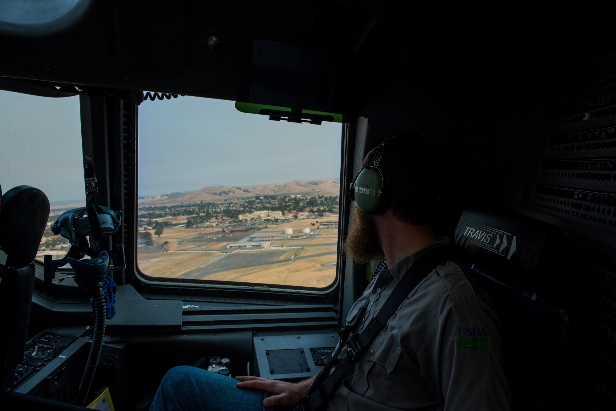 Matt Stevens, a U.S. Department of Agriculture airport biologist, looks out the window of a C-17 Globemaster III after taking off from Travis Air Force Base, Calif., July 2, 2018. The flight allowed Stevens, who helps manage the Bird/Wildlife Aircraft Strike Program at Travis to get a firsthand view of what pilots see during training flights near the base. (U.S. Air Force photo by Master Sgt. Joey Swafford)