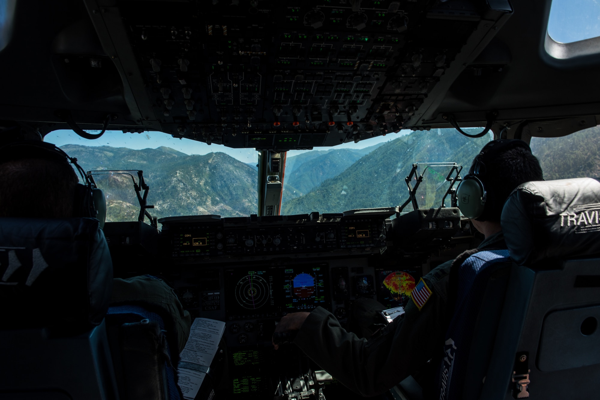 U.S. Air Force Capt. Sean Harte, right, 60th Air Mobility Wing Safety Office flight commander, and Capt. Doc Schumacher, 21st Airlift Squadron C-17 Globemaster III pilot, fly a C-17 over California during a safety office familiarization flight, July 2, 2018. The flight allowed Matt Stevens, a U.S. Department of Agriculture airport biologist, who helps manage the Bird/Wildlife Aircraft Strike Program at Travis Air Force Base, Calif., to get a firsthand view of what pilots see during training flights near the base. (U.S. Air Force photo by Master Sgt. Joey Swafford)