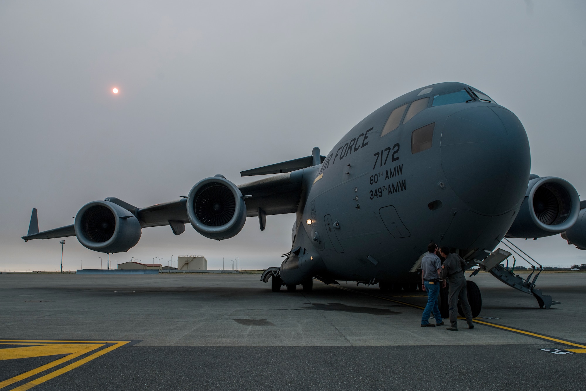 Matt Stevens, left, a U.S. Department of Agriculture airport biologist, and U.S. Air Force Capt. Sean Harte, 60th Air Mobility Wing Safety Office flight commander, go over C-17 Globemaster III pre-flight procedures before a safety familiarization flight at Travis Air Force Base, Calif., July 2, 2018. The flight allowed Stevens, who helps manage the Bird/Wildlife Aircraft Strike Program at Travis to get a firsthand view of what pilots see during training flights near the base. (U.S. Air Force photo by Master Sgt. Joey Swafford)
