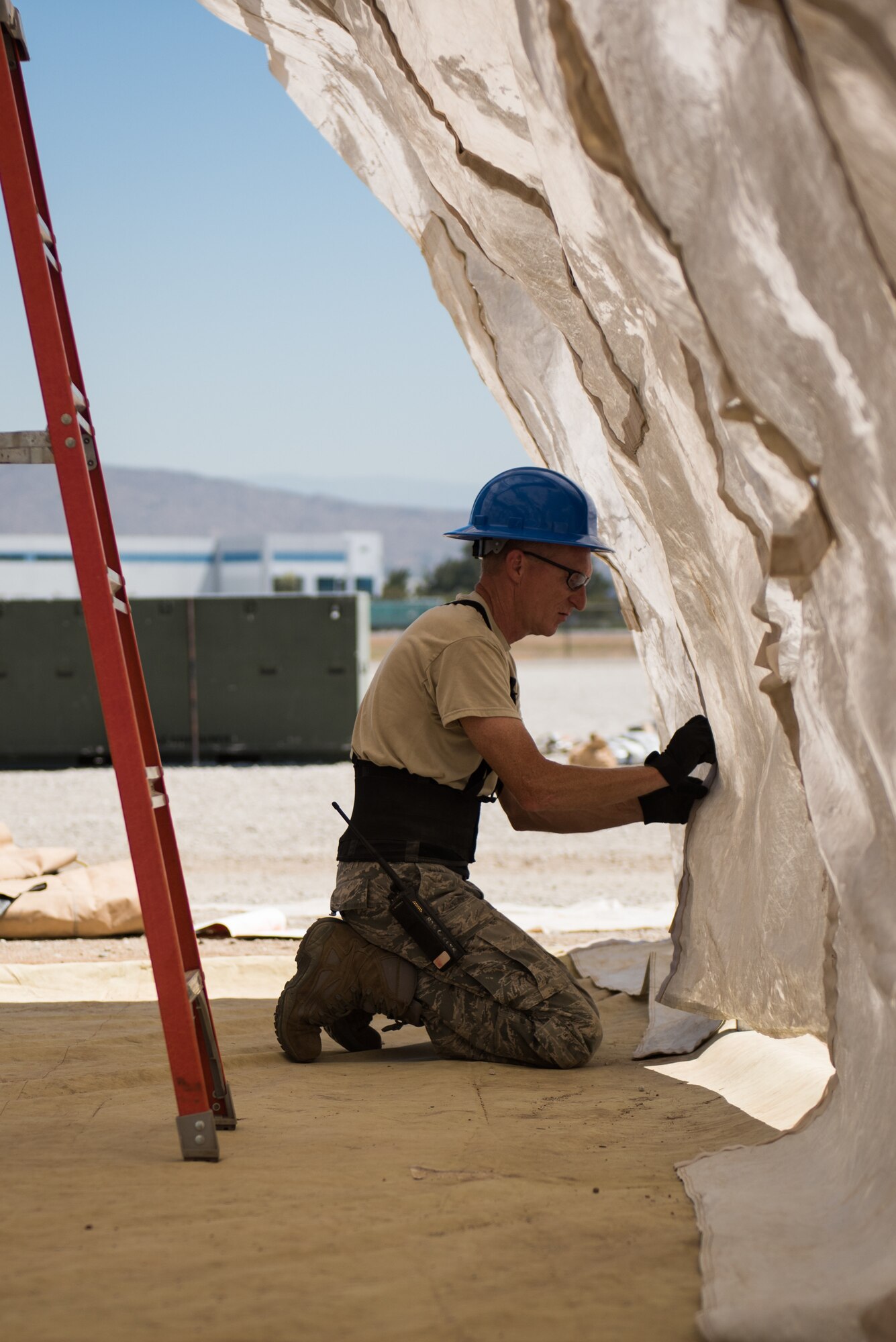 Tech. Sgt. Gary Elliot, a 137th Special Operations Civil Engineering Squadron (137th SOCES) structural craftsman, Oklahoma City, fastens a covering to a small structural shelter during deployment readiness training at March Air Reserve Base in Moreno Valley, California, June 27, 2018. The 137th SOCES members train at a regional training site every three years as a part of this deployment readiness training. (U.S. Air National Guard photo by Staff Sgt. Brigette Waltermire)