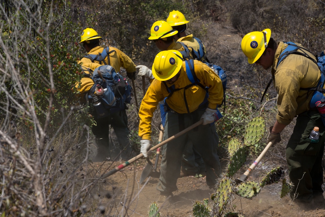 U.S. Marines piloting UH-1Y Huey helicopters and firefighters from Camp Pendleton as well as surrounding communities work together to contain a 1,200 acre fire in the Camp Horno area at Marine Corps Base Camp Pendleton, California, July 7, 2018. (U.S. Marine Corps photo by Cpl. Lukas Kalinauskas)