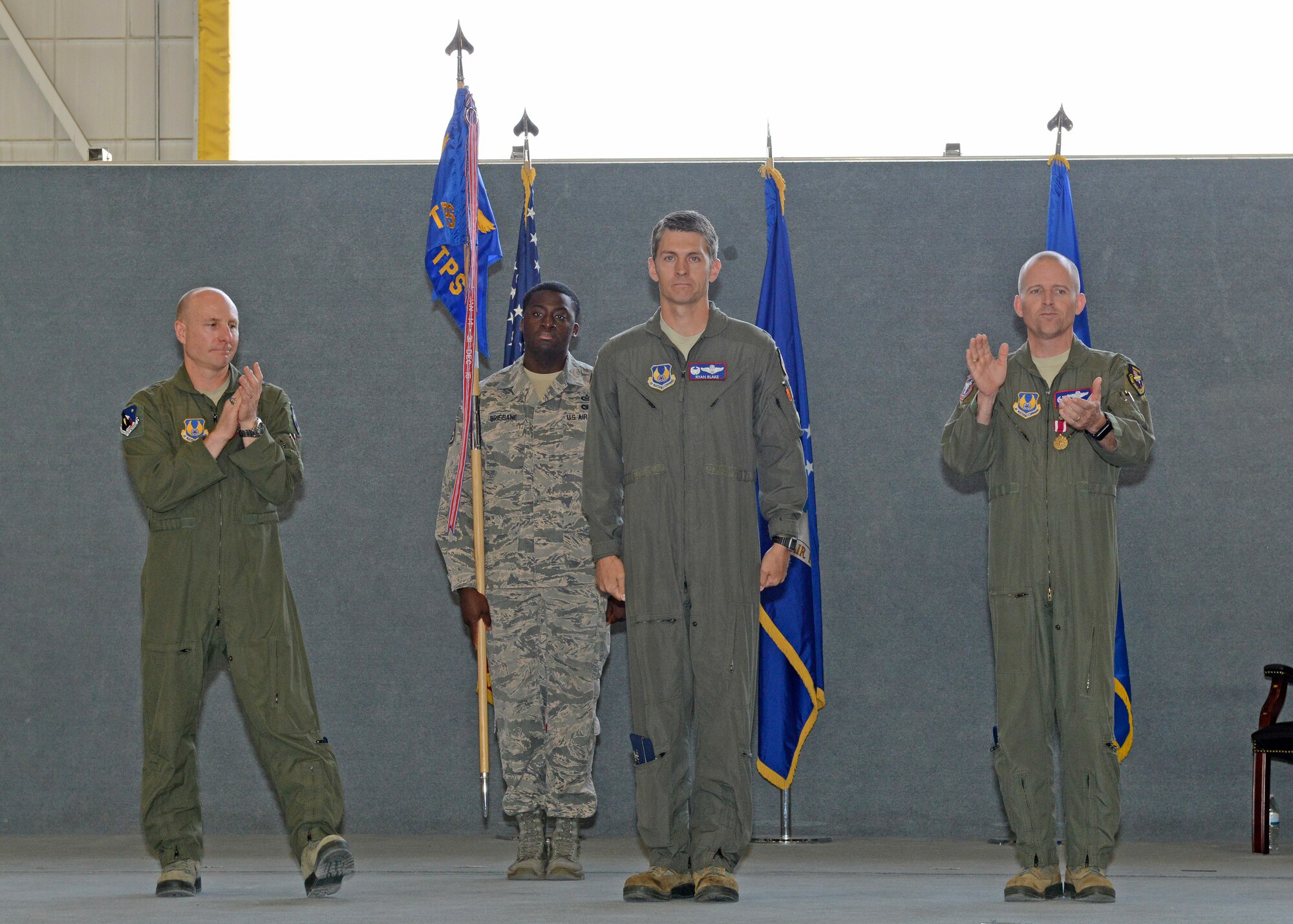 New U.S. Air Force Test Pilot School commandant Col. Ryan Blake (center) is flanked by Brig. Gen. Carl Schaefer, 412th Test Wing commander (left), and outgoing commandant, Col. Matthew Higer (right), during a change of command ceremony in Hangar 1207 July 10. (U.S. Air Force photo by Kenji Thuloweit)