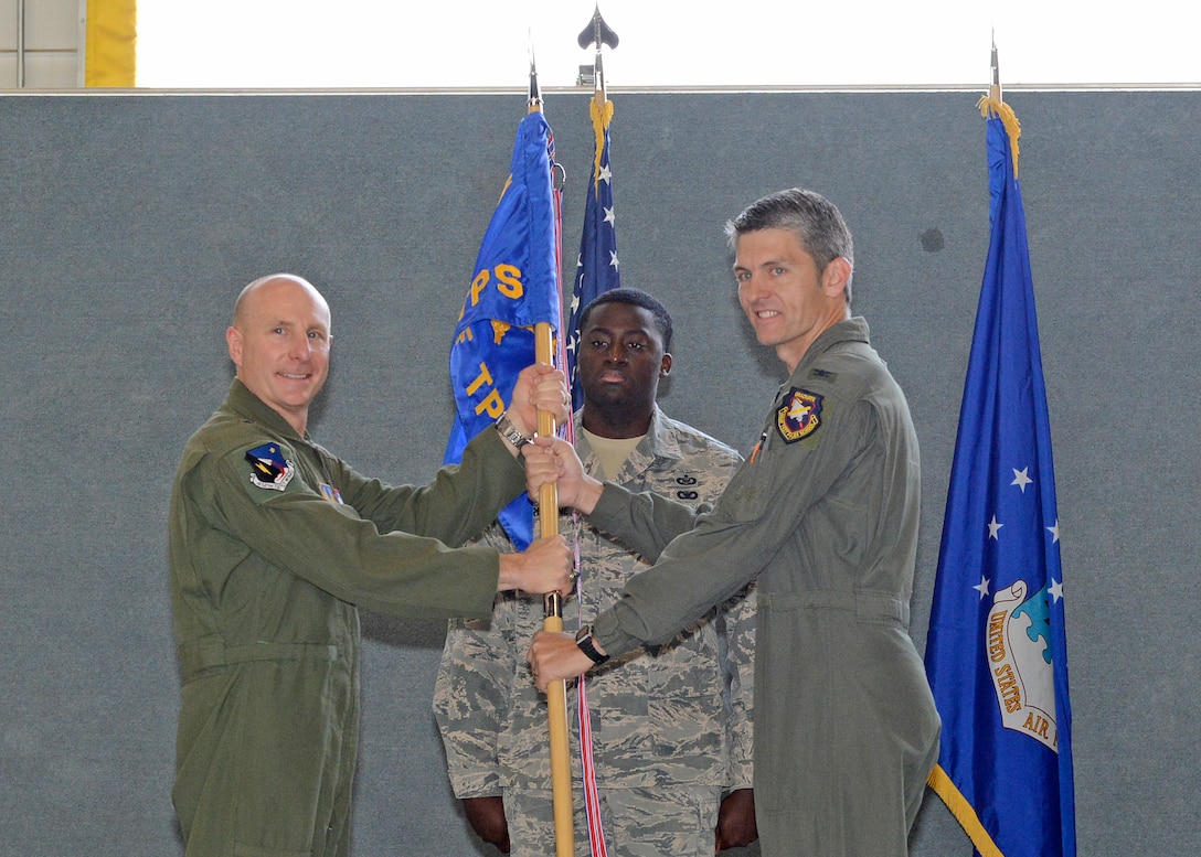 Brig. Gen. Carl Schaefer, 412th Test Wing commander (left), and new U.S. Air Force Test Pilot School commandant, Col. Ryan Blake, pose with the school’s guidon during a change of command ceremony in Hangar 1207 July 10. (U.S. Air Force photo by Kenji Thuloweit)