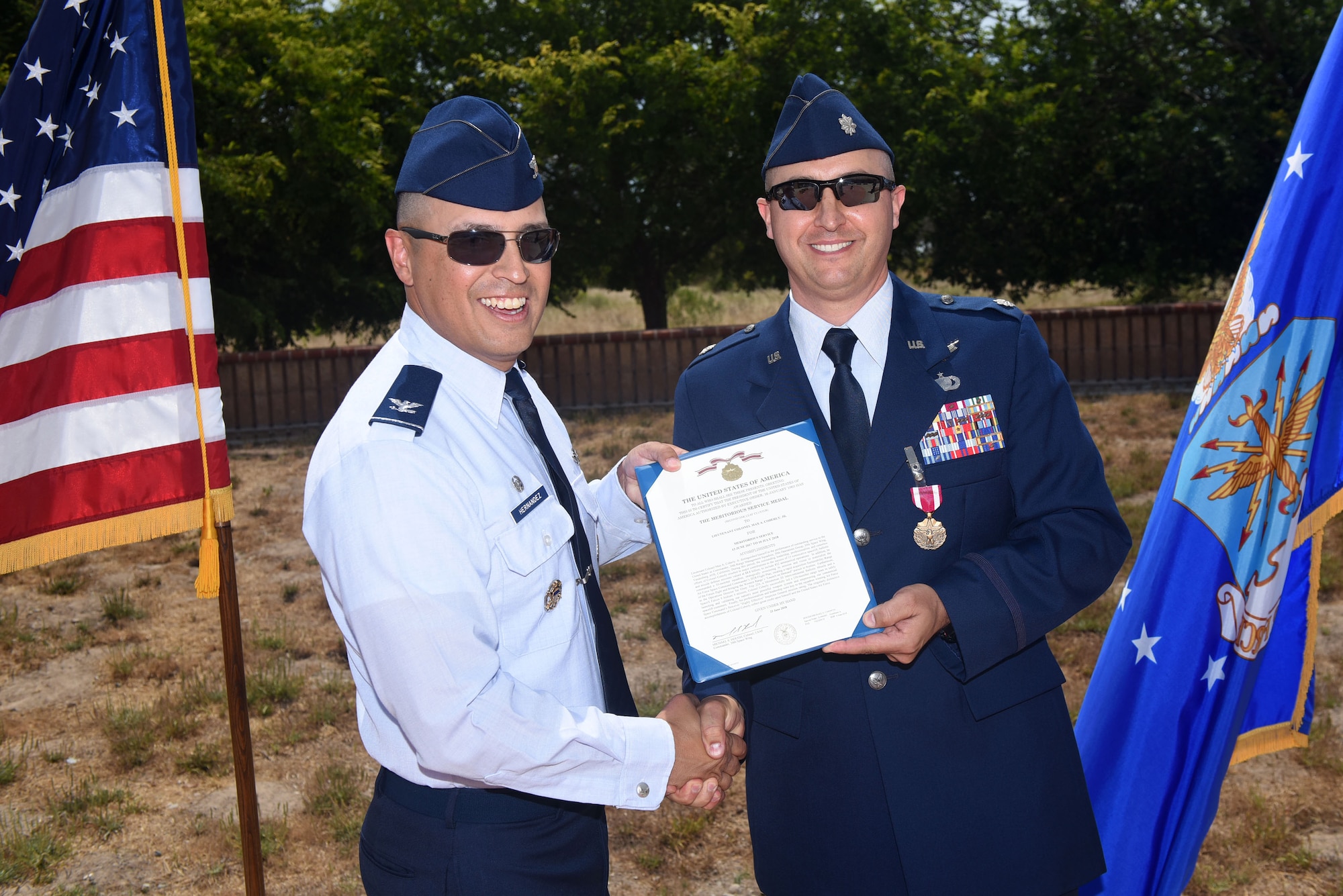 Col. Curtis Hernandez, 30th Operations Group commander, presents the meritorious service medal to Lt. Col. Max Coberly, 30th Range Management Squadron commander, at Vandenberg Air Force Base, Calif., on July 10, 2018. Coberly was presented the medal shortly after the inactivation of the 30th RMS. (U.S. Air Force photo by Tech. Sgt. Jim Araos/Released)