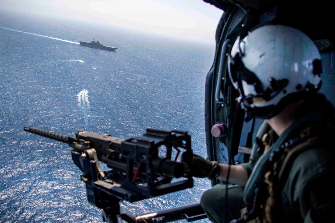 From a helicopter, a sailor observes the amphibious assault ship USS Kearsarge.