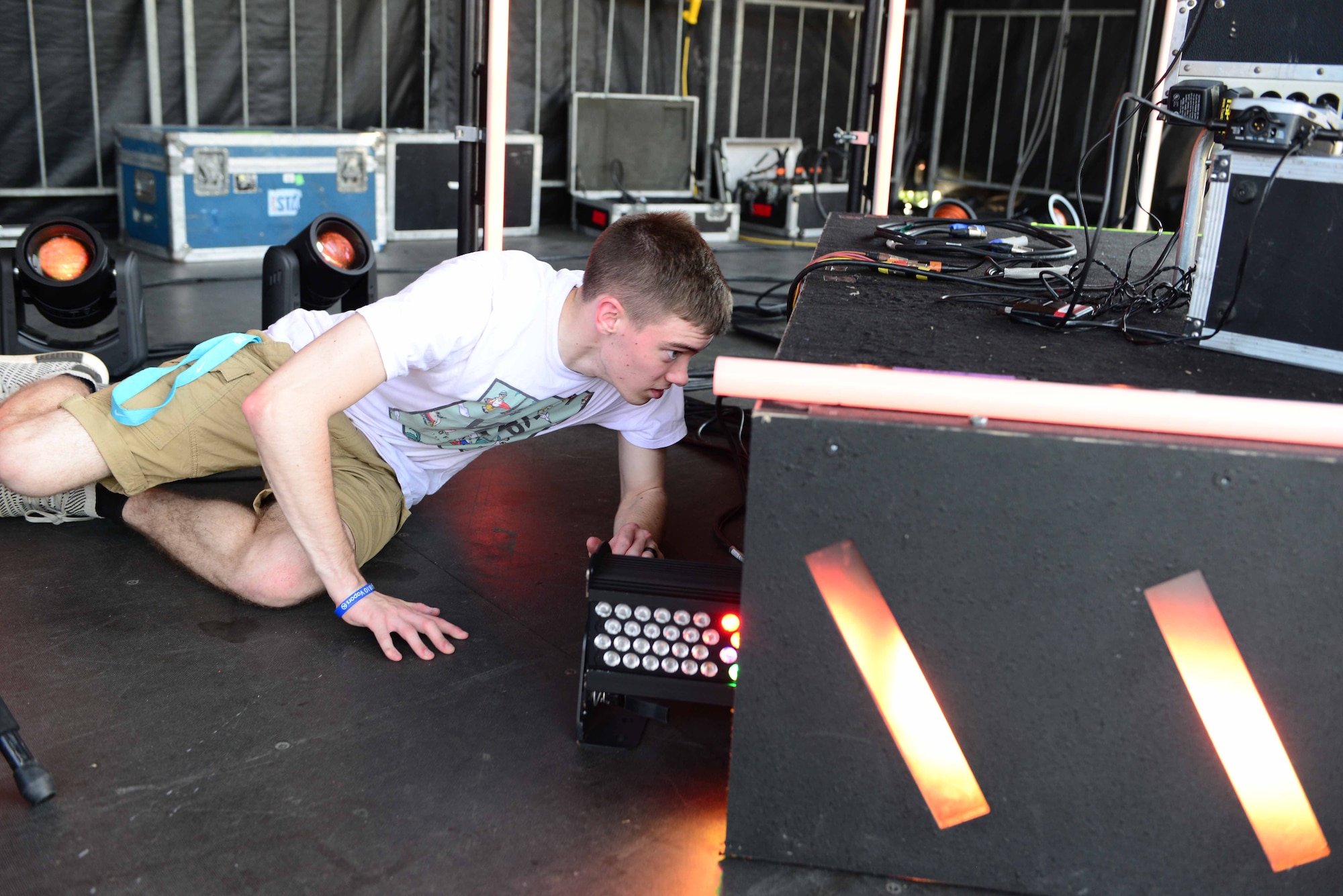 Airman 1st Class Anthony Connors, 14th Force Support Squadron personnelist, hooks up lights on stage July 6, 2018, on Columbus Air Force Base, Mississippi. Air Force Entertainment and participating bases agreed that base personnel would provide volunteers to assist the stage crew in setting up and running the event. (U.S. Air Force photo by Airman 1st Class Beaux Hebert)