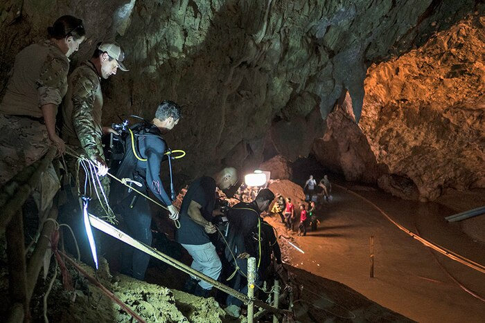 People walk into a cave.