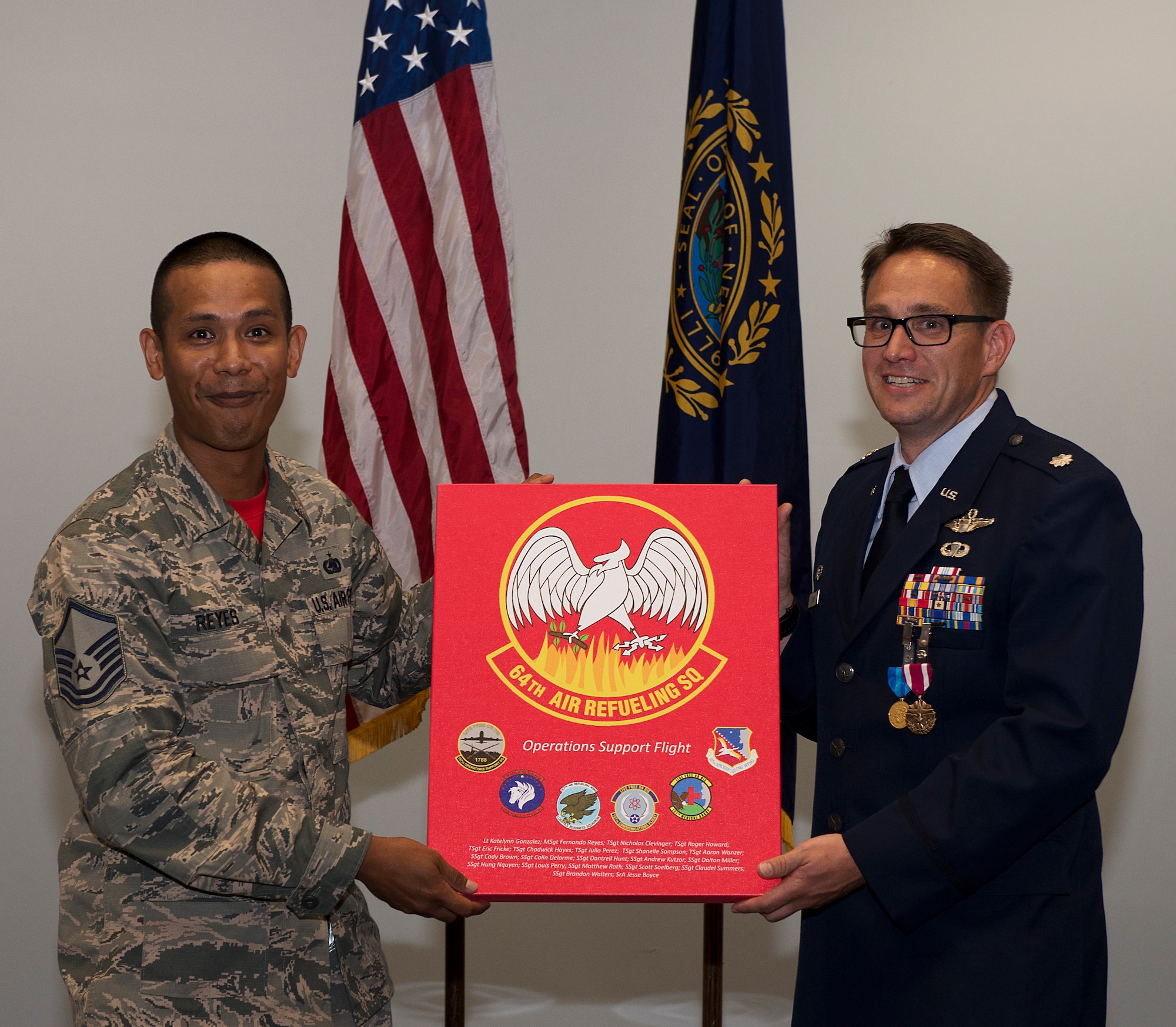 Lt. Col. Joshua J. Zaker, commander of the 64th Air Refueling Squadron, receives a gift from Master Sgt. Fernando B. Reyes, superintendent of the 64th Operations Support Flight, during a ceremony on July 6, 2018 at Pease Air National Guard Base, N.H. Zaker relinquished command of the 64th ARS after more than three years as the commander. (N.H. Air National Guard photo by Staff Sgt. Kayla White)
