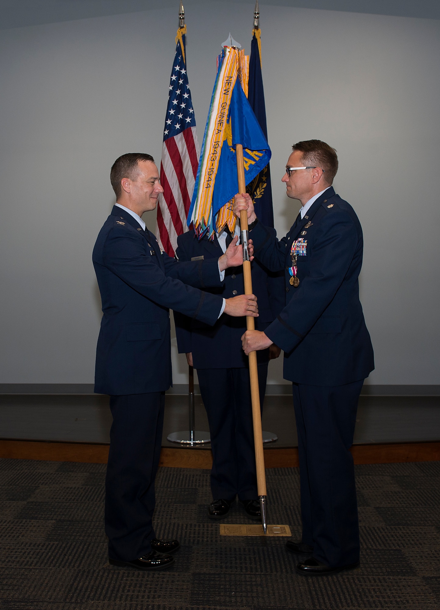Lt. Col. Joshua J. Zaker, commander of the 64th Air Refueling Squadron, passes the 64th ARS guidon to Col. Robert L. Hanovich JR, commander of the 22nd Operations group at McConnell Air Force Base, Kan. during a ceremony on July 6, 2018 at Pease Air National Guard Base, N.H. Zaker relinquished command of the 64th ARS after more than three years as the commander. (N.H. Air National Guard photo by Staff Sgt. Kayla White)